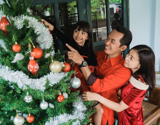 People decorating Christmas Tree